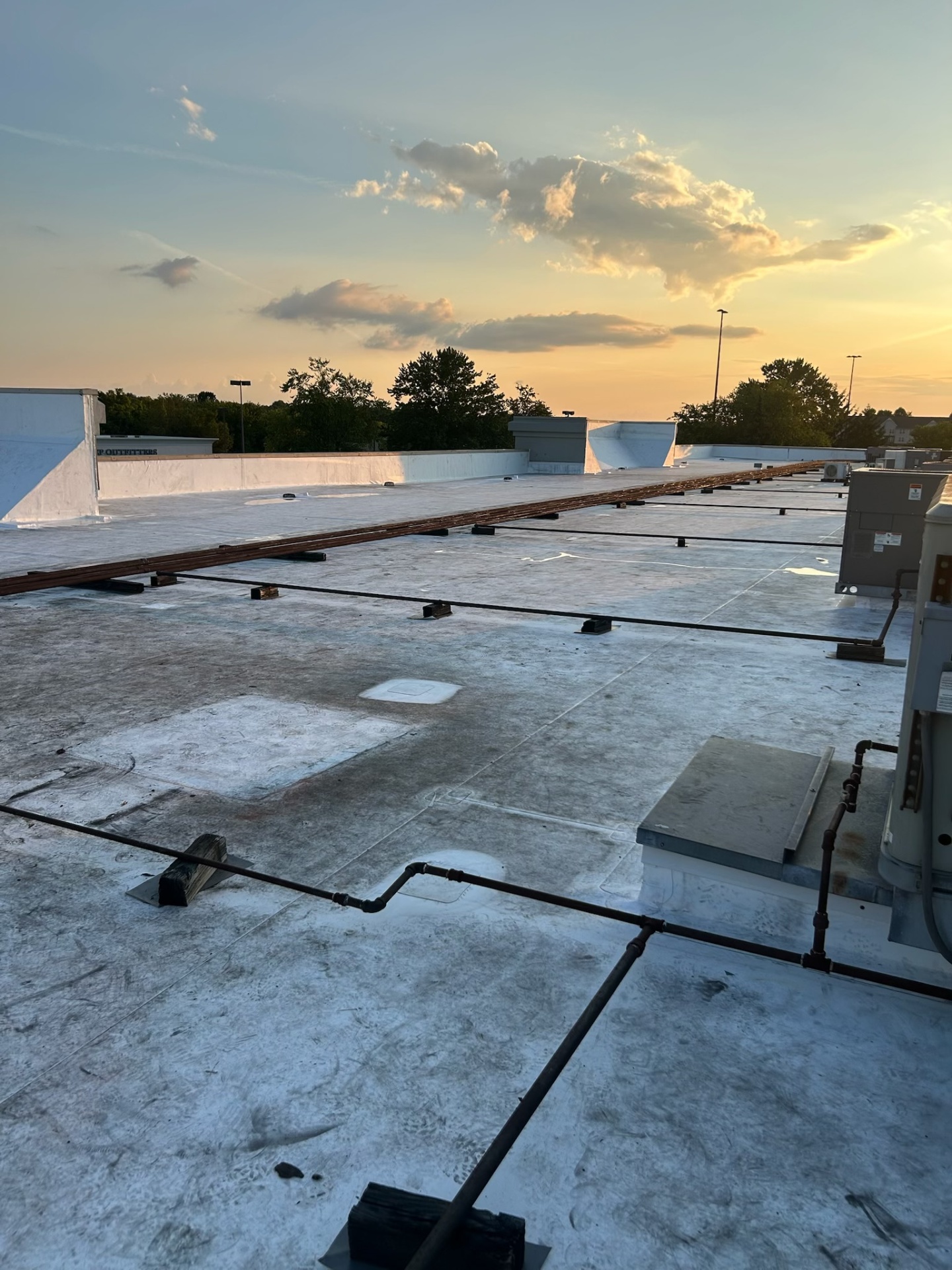 Large commercial flat roof project at sunset